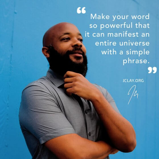 JClay holding beard in front of blue wall with inspirational quote