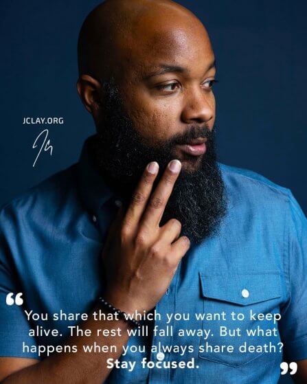 inspirational quote by jclay over an image of him wearing a teal shirt with 2 fingers held to beard
