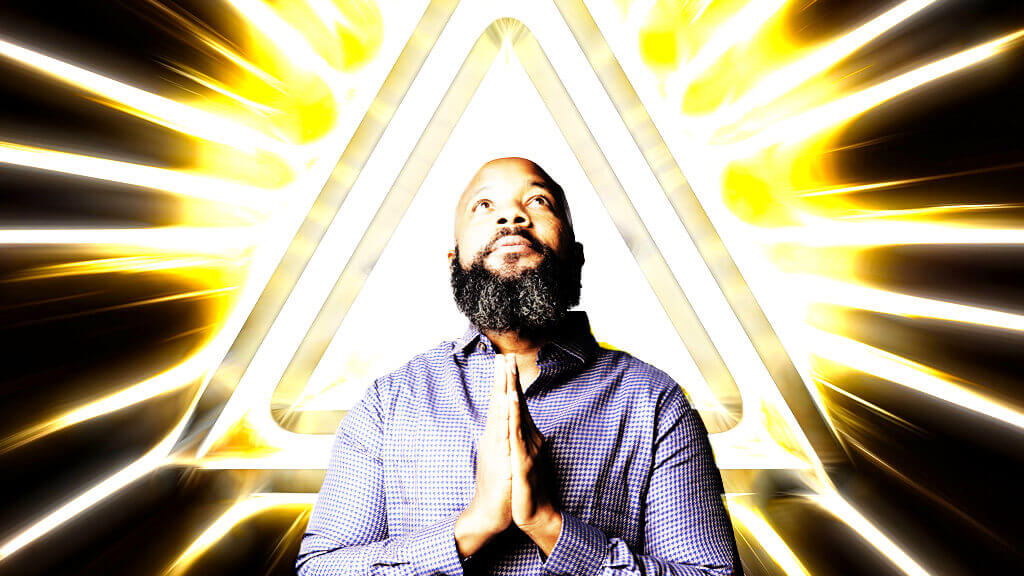 jclay brown praying hands with bright light triangle behind him