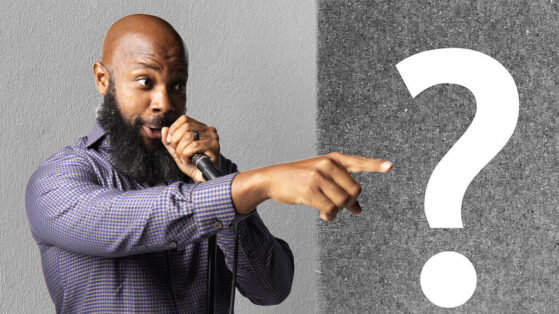 jclay holding a mic and pointing with a question mark